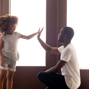 African American dad give high five to small daughter