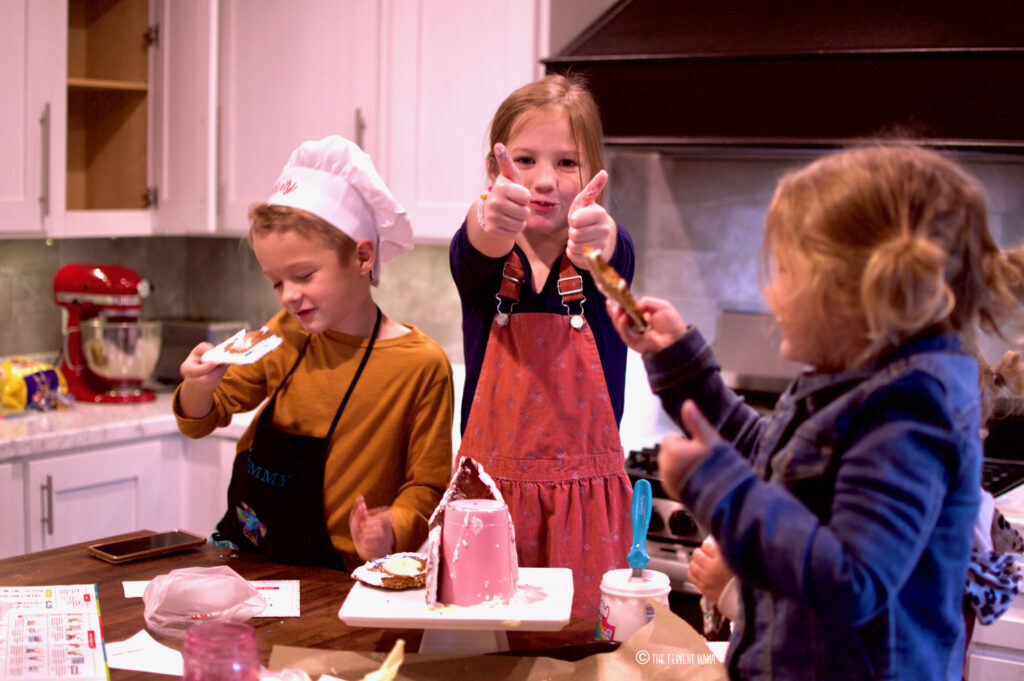 a group of children eating a gingerbread house.