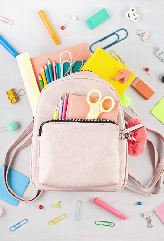 Student pink backpack and various school supplies. Studing, education and back to school concept