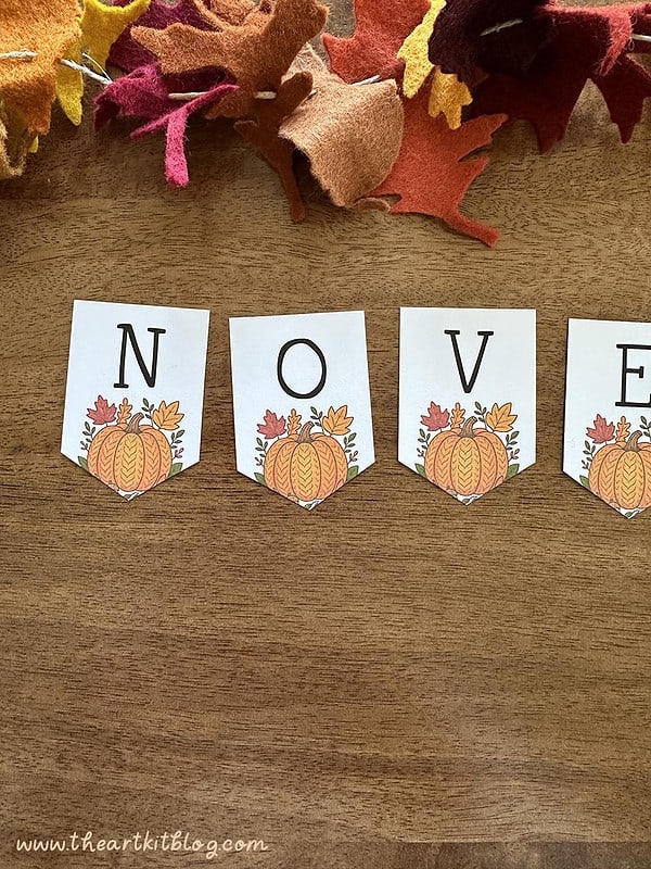 november-banner-pumpkin-printable-2 Colorful fall-themed felt leaves, perfect for autumn crafts and classroom decorations, arranged near educational flashcards spelling "NOV" with pumpkins and leaves.