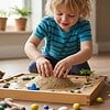 Young boy engaging in educational play with a sand table, surrounded by small toys and a miniature palm tree, in a bright home setting.