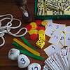 Exif_JPEG_420 Educational game setup with dominoes, playing cards, dice, and scorecards for homeschooling activities.