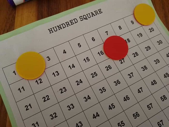 WhatsApp Image 2024-02-24 at 16.29.22 (2) Educational hundred square chart with colored counters for math learning.
