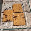blondies bars (2000 x 2000 px) (1) Four homemade chocolate chip cookie bars in a glass baking dish on a marble countertop.