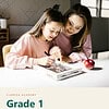 clareza-grade1.jpg Mother and daughter doing homework together at a table, with a red apple nearby, in a cozy home setting.