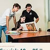 clareza-specials10-pe.jpg Three students studying a large art book at a desk in a classroom, with one student seated and two standing, engaging in a discussion about the artwork.