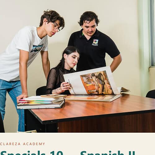 Three students studying Spanish II at ClarezA Academy, with one student reading a book while two others look on, in a classroom setting.